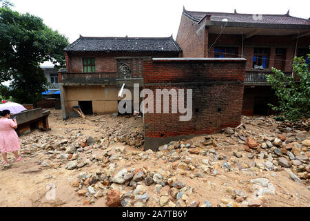 Gli abitanti di un villaggio di controllare la distruzione causata dai torrenti di montagna e prendere la roba ritornare dal distrutto casa nella contea di Lantian, Xi'an City, a nord-ovest della Cina di Foto Stock