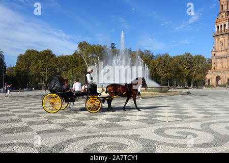 Siviglia, Spagna 26 ottobre 2014: turisti tenendo a cavallo e cavalcare carrello attraverso la Plaza de Espana in Siviglia Foto Stock