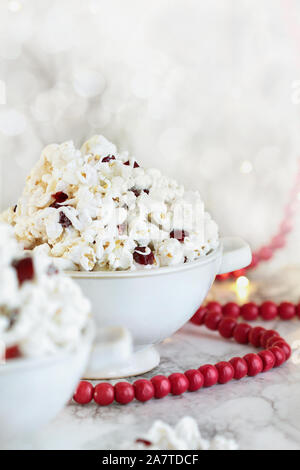 In casa di popcorn e mirtilli secchi snack ricoperto di cioccolato bianco pronto per le vacanze. Messa a fuoco selettiva con sfocato in primo piano e sullo sfondo. Foto Stock