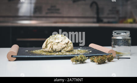 Preparazione per la cottura di canapa o torta di pane. Close-up di pasta fresca con la farina di cannabis. Concetto di utilizza la marijuana in una industria alimentare Foto Stock