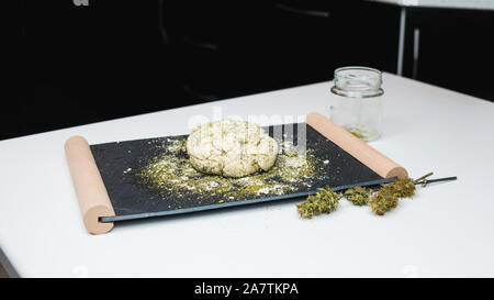 Preparazione per la cottura di canapa o torta di pane. Close-up di pasta fresca con la farina di cannabis. Concetto di utilizza la marijuana in una industria alimentare Foto Stock