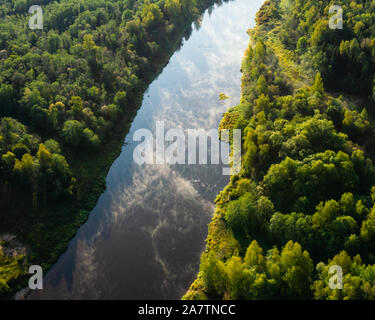 Warm vista aerea di colori d'autunno alba al coperto di foresta pittoresca Europa settentrionale della valle del fiume. La consistenza della nebbia di luce sopra il magnifico Foto Stock