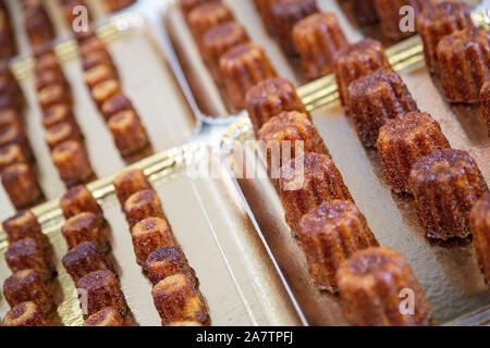 Pieno di cannele posto su una piastra. Cannele è un regionale francese specialità di pasticceria Foto Stock