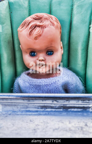 Vintage Scary sporco Creepy Doll seduto in un vecchio neonato o bambino sedia alta Foto Stock