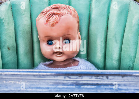 Vintage Scary sporco Creepy Doll seduto in un vecchio neonato o bambino sedia alta Foto Stock