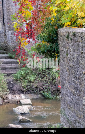 La scalinata in pietra che conduce al fiume Brue vicino Packhorse Bridge in BRUTON, SOMERSET REGNO UNITO, fotografato in autunno con le foglie degli alberi modifica colori Foto Stock