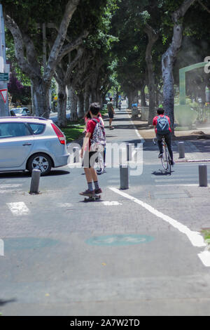 Tel Aviv, Israele - 10 Maggio 2017: ragazzi adolescenti sono il pattinaggio e ciclismo in Rothschild Boulevard Park a Tel Aviv Center. Foto Stock