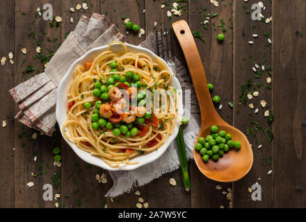 Vista superiore piatto di spaghetti con gamberi con piselli e pomodorini Foto Stock