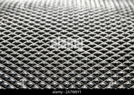 Abstract macro close-up di industriale di colore nero circolare in metallo con la parte densa schema a piramide in rilievo a fuoco parziale Foto Stock