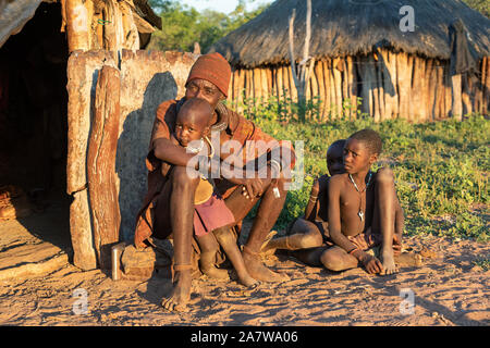 La Namibia, Regione di OMUSATI, 6 maggio: stropicciata Himba uomo vecchio con i bambini di fronte al rifugio. Gli Himba sono indigeni della Namibia di persone di etnia, nel nord Foto Stock