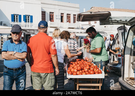 La città di Mykonos, Grecia - 20 Settembre 2019: Donna comprando i pomodori da un venditore ambulante in Hora, conosciuta anche come la città di Mykonos, capitale dell'isola e o Foto Stock