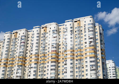 Facciata di alta beige moderni edifici residenziali sul cielo blu con nuvole bianche vista orizzontale Foto Stock