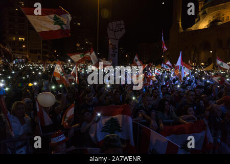 Beirut, Libano. 3 Novembre, 2019. Manifestanti alzare i loro telefoni cellulari seguenti canti politici chiedono una modifica al settario basata su sistema politico in Libano. I dimostranti si sono riuniti per il diciottesimo giorno nel centro di Beirut in migliaia. Domenica 3 novembre 2019 Credit: Sima Diab/ZUMA filo/Alamy Live News Foto Stock