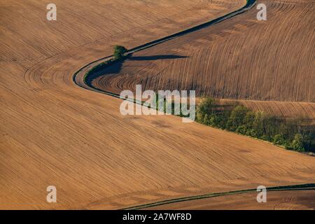 Avvolgimento su strada attraverso campi in primavera sulla foto aerea. Foto Stock