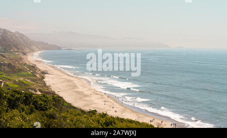 Vista dell'Oceano Pacifico dall'alto su impianto coperto duna di sabbia cliff, foggy sky, laminazione marea sulla spiaggia sabbiosa Foto Stock