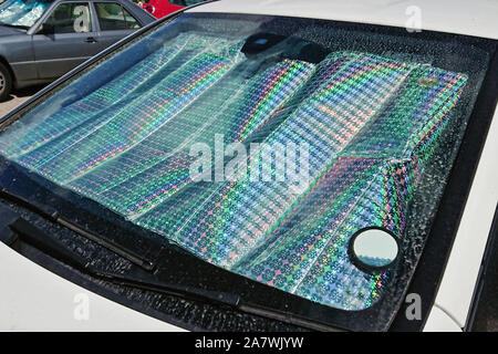 Parabrezza della vettura con protezione solare riflettente superficie interno auto parcheggiate street giornata calda. Metodo per proteggere riscaldata dai raggi del sole all'interno dell'auto Foto Stock