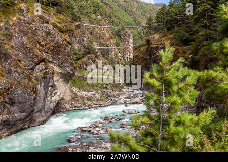 Sospensione ponte sul Campo Base Everest Trek, l'Himalaya, il Parco Nazionale di Sagarmatha, Nepal. Maestoso fiume. Foto Stock