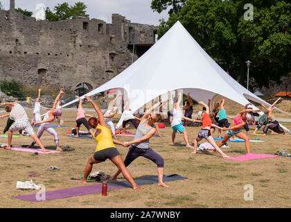 Persone che praticano lo Yoga durante il festival di yoga in terra di Haapsalu Castle di Haapsalu, Estonia Foto Stock