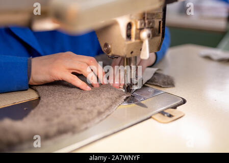 I dettagli di cucitura di pelliccia e cuoio. Produzione di calzature. Foto Stock