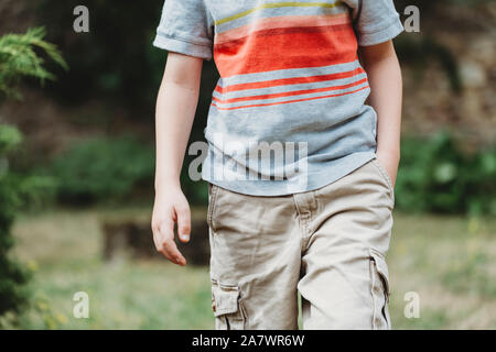 Vista ravvicinata del bambino di metà sezione con la mano in tasca Foto Stock