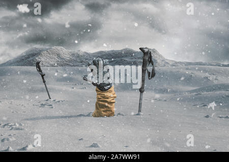 Escursionista stendendo la coperta di neve mano accanto a pali trekking alla guida del segnale a causa di valanghe di neve . Pericolo estrema Foto Stock