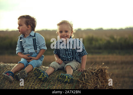 Ritratto di Allegro bambini seduti sul cumulo Foto Stock