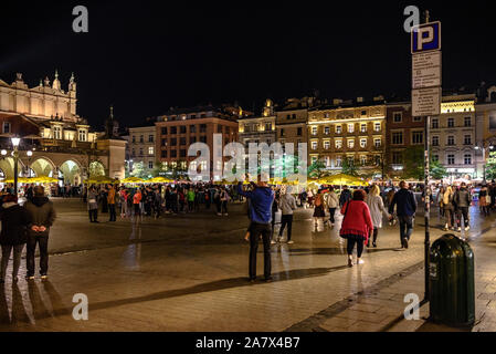 I turisti in Rynek Glowny, la piazza principale della città vecchia di Cracovia di notte Foto Stock