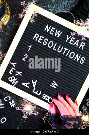 Capodanno risoluzioni flatlay con lettera e bordo nero e oro decorazioni di partito. Foto Stock