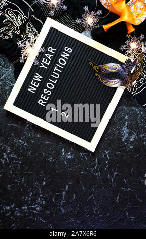 Capodanno risoluzioni flatlay con lettera e bordo nero e oro decorazioni di partito con il polo negativo a copiare lo spazio. Foto Stock