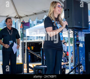 Donna sul palco risolve la folla come Devin Christopher, gli angeli Baseball annunciatore, guarda su durante la JDRF uno a piedi fundraiser presso Angel Stadium. Foto Stock
