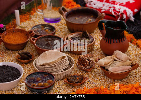 Una vera e propria rurale messicano tradizionale altare per il giorno dei morti con calendula petali di fiori gialli, tamales, mole, riso, tortillas, cibo messicano, traditi Foto Stock