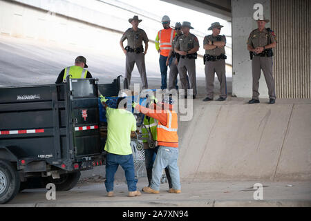 Texas Department of Transportation appaltatori pulire sotto un cavalcavia a U.S. La Highway 290 West come completano il lavoro ordinato dal Texas Gov. Greg Abbott per ripulire le aree senzatetto di Austin. Foto Stock