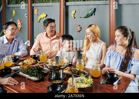 Felice grande famiglia asiatica di gustare la cena in ristorante insieme e mangiare piatti tradizionali Foto Stock