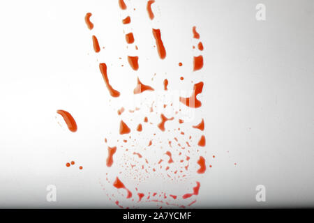 Mano rossa stampare un bianco sfondo sporco. Concetto di pericolo, la festa di Halloween. Bloody red trail di una mano rossa scende in forma di Palm Foto Stock