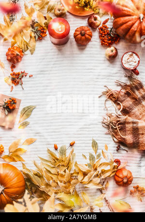 Autunno verticale con sfondo giallo lascia cadere, zucche, sciarpa, cappuccino, candele accese, mele e rowan. Vista dall'alto. Accogliente layout autunnale wi Foto Stock