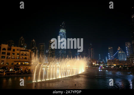 Acqua & Light show nel centro città di notte con tutti i skyscrappers accesa e riflettendo nel lago, Dubai, Emirati Arabi Uniti. Foto Stock