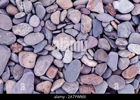 Pietre lisce sfondo texture. Pietre arrotondate sull Oceano Atlantico costa. Foto Stock