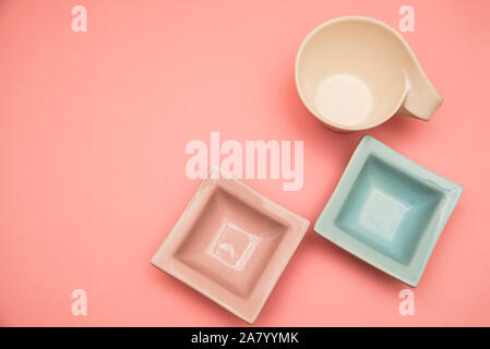 Due piccoli da tavolo decorativo bocce rosa e azzurro e un bicchiere di bianco su una rosa backround Foto Stock