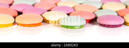 Banner, biscotti o Macarons vari colorato su sfondo bianco, concetto dolciumi Foto Stock