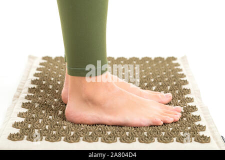 Feets femmina senza scarpe sorge su un tappeto di sport, profil Foto Stock