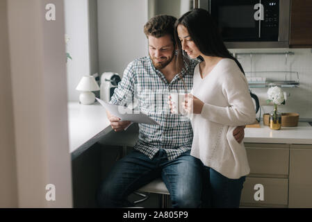 Attraente giovane coppia sposata ouple studiare ipoteca documenti insieme Foto Stock