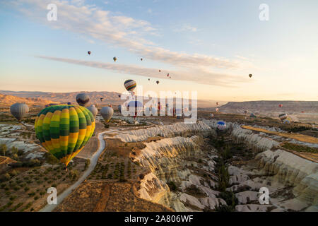 Di Göreme, Cappadocia, Turchia - 7 Ottobre 2019: i palloni ad aria calda galleggiando giù valli nel Parco nazionale di Göreme venendo a terra dopo un volo mattutino. Foto Stock
