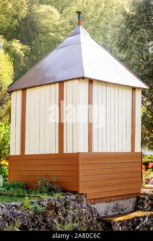 Selfmade backyard shed in giardino per gli attrezzi da giardino e spazio di archiviazione, sullo sfondo di legno Foto Stock