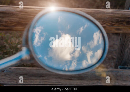 Specchietto retrovisore in stile vintage - il cielo e le nuvole sono riflessi nello specchio Foto Stock