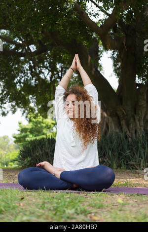 La donna a praticare yoga nel parco di Lodhi Garden a Nuova Delhi in India Foto Stock