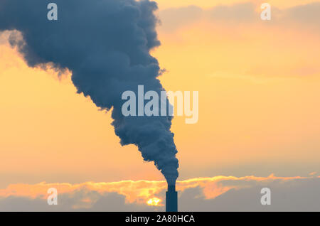 Eruttazione di fumo da un fumaiolo industriale o camino causando aria e inquinamento atmosferico in un riscaldamento globale concetto Foto Stock