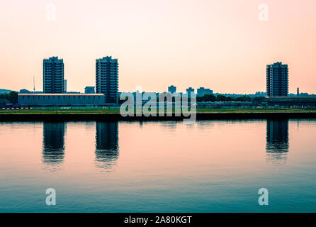 Il North Woolwich skyline, con i blocchi a torre riflessa sul Tamigi canal. Nord Woolwhich è un insediamento industrializzati nei Docklands, East London Foto Stock