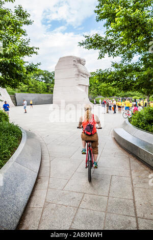 Una donna si avvicina il Martin Luther King Jr memorial su una bici, Washington, Stati Uniti d'America. Foto Stock