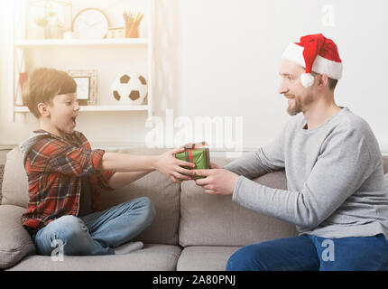 Padre dando il proprio figlio un regalo di Natale a casa Foto Stock