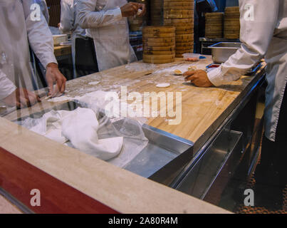 Un gruppo di chef rendendo gnocchi Cinesi Foto Stock